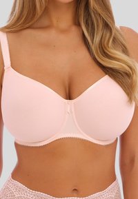 Sostenedor de color rosa claro con textura suave, soporte de varilla y acentos de encaje a lo largo de los bordes. Presenta tirantes ajustables y un cierre frontal.