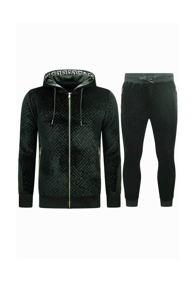 Zwart fluwelen trainingspak met een rits-hybride hoodie met een geometrisch patroon en gouden hardware, gecombineerd met tapse broekspijpen met elastische boorden.