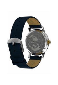 Edelstahl Timex Uhr mit einem marineblauen veganen Lederarmband, goldener Krone und graviertem Globusdesign auf der Rückseite des Gehäuses.