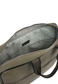 Bolso de cuero verde oliva con superficie texturizada, cierre de cremallera y asas negras. El interior cuenta con un forro claro gris con un patrón.