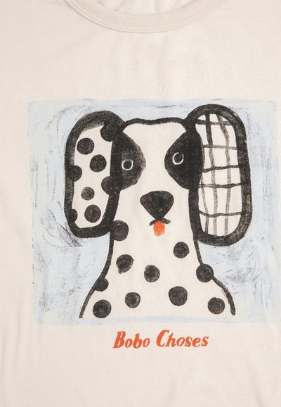 Cane maculato bianco e nero con la lingua fuori, un orecchio a pois e l'altro a scacchi, su uno sfondo chiaro con il testo "Bobo Choses" in basso.