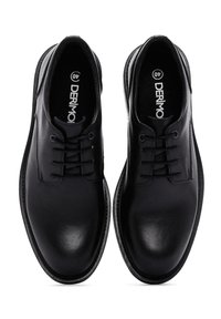 Chaussures habillées en cuir noir avec une finition lisse, à lacets, bout rond et semelle plate. Marque visible à l'intérieur de la chaussure.
