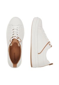 Białe tenisówki o gładkim wykończeniu, z brązowymi akcentami na pięcie i boku oraz białymi sznurówkami. Posiadają wytrzymałą gumową podeszwę i materiałowe wykończenie wewnętrzne.