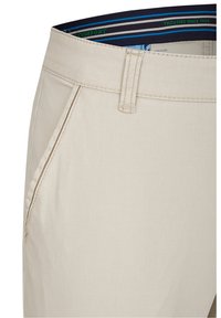 Beige cotton chinos featuring a straight cut, subtle stitching details, two front pockets, and a striped waistband with blue accents.