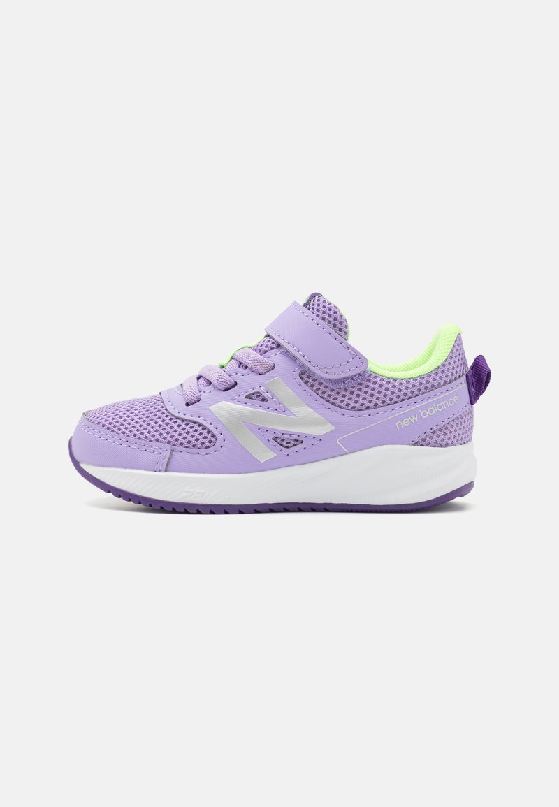 Baskets en maille violette avec un logo argenté, design à lacets et bande Velcro. Présente une semelle blanche et violette avec des accents texturés.