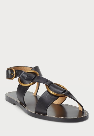 Melni ādas sandales ar savstarpēji savienotām zelta gredzeniem, platu zoli, atvērtu purngali un regulējamu potītes siksniņu drošai piegulšanai.