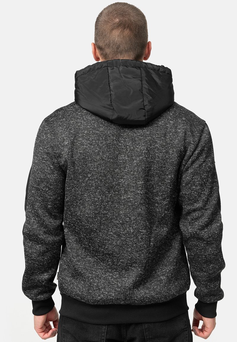 Zwarte en grijze melange hoodie met een gewatteerde zwarte capuchon, geribbelde manchetten en tailleband, met een gestructureerde stofafwerking.