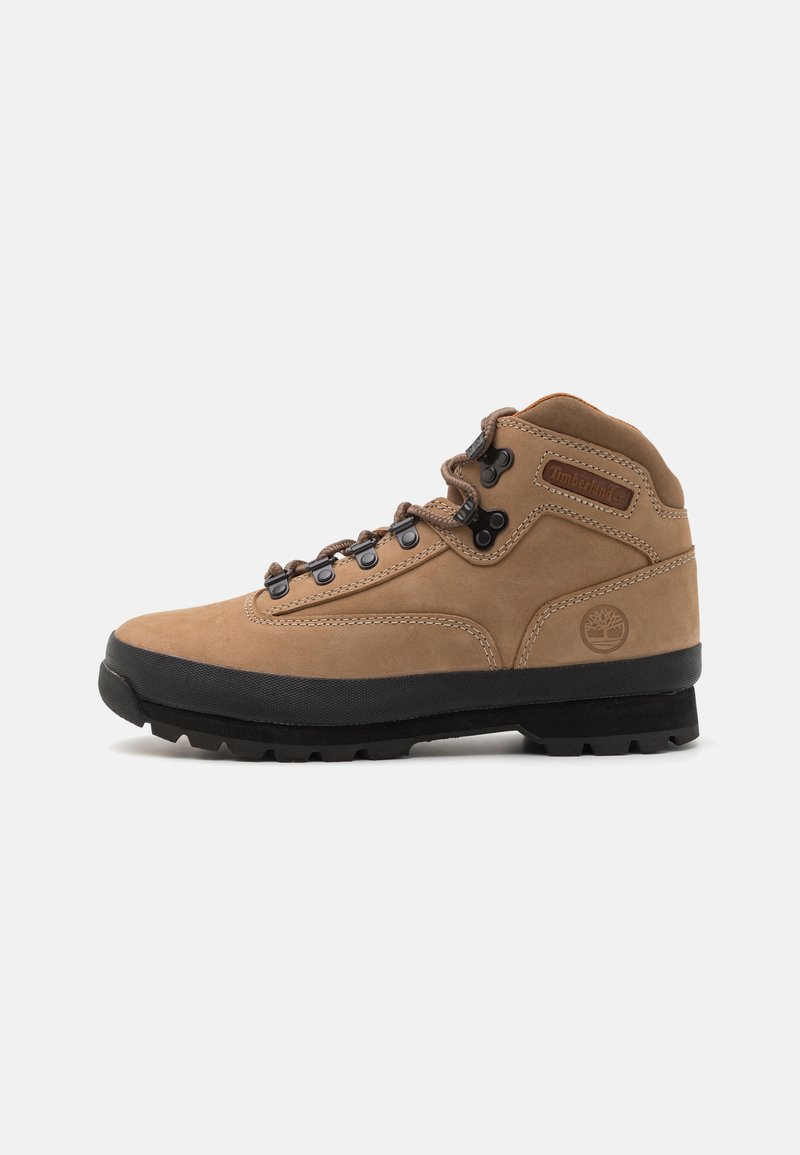Stivale da trekking in suede marrone con suola in gomma nera, design con lacci e colletto imbottito. Logo Timberland sul lato.