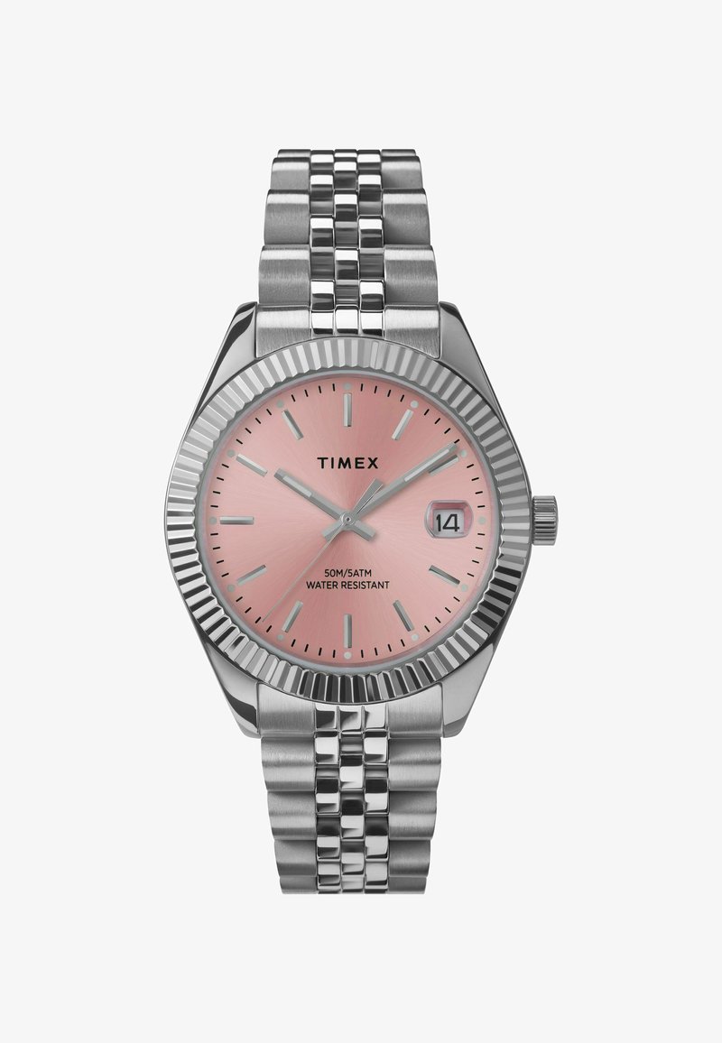 Montre-bracelet Timex avec un cadran rose, des marqueurs argentés et un bracelet en acier inoxydable. Dispose d'une lunette cannelée et d'un affichage de la date à 3 heures. Résistante à l'eau jusqu'à 50m.