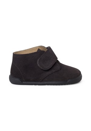 Stivale alla caviglia in suede nero con punta arrotondata, chiusura con strap in Velcro e suola in gomma testurizzata. Design semplice, materiale durevole.
