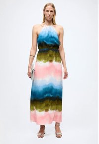 Maxikjole med halterneck, med et gradientmønster i blått, grønt og rosa. Laget av lett stoff med et flytende design.