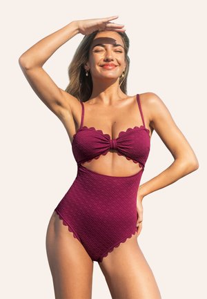 Maillot de bain une pièce bourgogne avec un devant noué, des bords festonnés, un motif en losanges texturé et des côtés découpés, doté de fines bretelles.