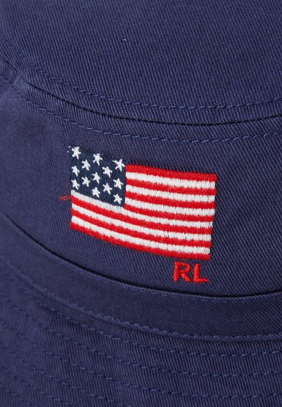 Mørkeblå bøttehatt med teksturert stoff, med en brodert amerikansk flagg og rødt "RL"-logo foran.