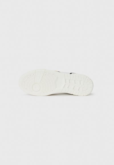 Talpa de adidași alba cu cauciuc texturat, modele circulare și caneluri orizontale. Design curat cu accente minime și construcție durabilă.