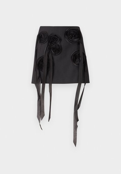 Črna krila, okrašena s tridimenzionalnimi cvetličnimi aplikacijami in dolgimi, flowing satenastimi trakovi. Material ima gladko teksturo in strukturiran dizajn.