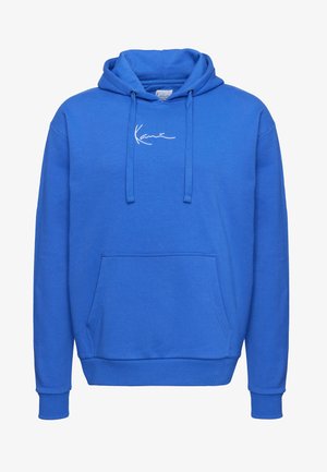 Modra jopa iz mehkega blaga z žepom spredaj, kapuco z vrvico in belim izvezenim logotipom na prsih. Dolgi rokavi z rebrastimi manšetami.