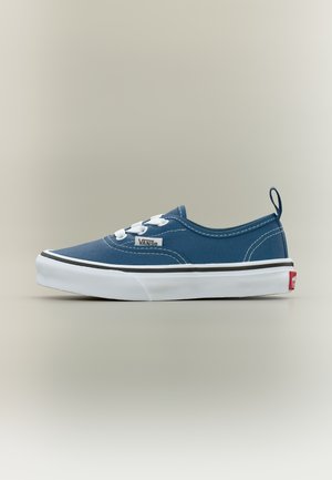 Μπλε παπούτσι Vans χαμηλού προφίλ με λευκά κορδόνια, λευκή καουτσούκ σόλα, μαύρη λεπτομέρεια γραμμής και κόκκινη ετικέτα λογότυπου στη φτέρνα πάνω σε απλό φόντο.