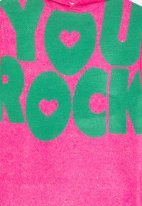 Hoodie rose vif avec un grand texte vert qui dit "YOU ROCK" avec des accents en forme de cœur à l'intérieur des lettres. Texture scintillante sur l'ensemble.
