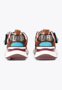 Pair of colorful sneakers viewed from the back, featuring brown, blue, pink, and white accents with "KURT" letters on the heel tabs.