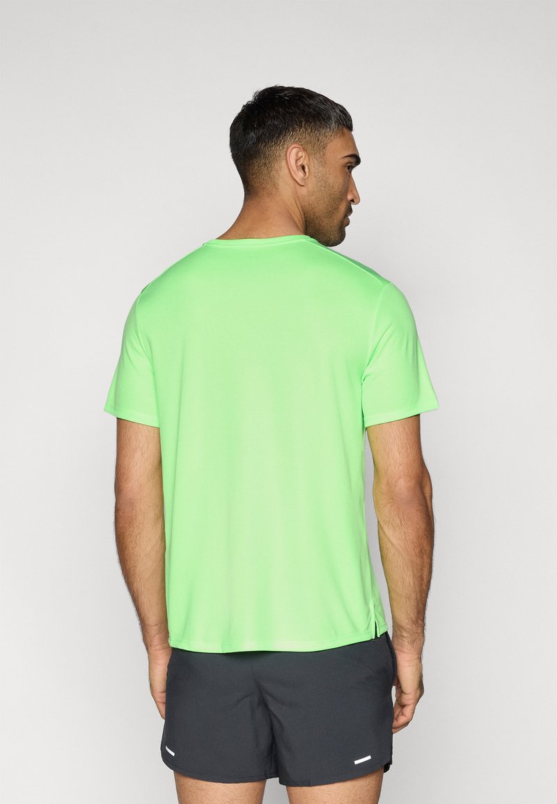 Kurzärmliges Sportshirt in leuchtendem Grün, hergestellt aus einem leichten Stoff. Verfügt über einen Rundhalsausschnitt und Seitenschlitze für mehr Bewegungsfreiheit.