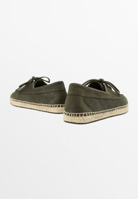 Olivengrønne slip-on sko lavet af blødt stof med en vævet jute sål. Har snøre detaljer foran og en rund tådesign.