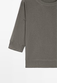 Pull en maille gris à manches longues avec poignets et ourlet côtelés, doté d'un col rond et d'une coupe décontractée.