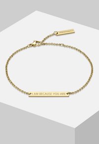 Bracelet en or avec un design en chaîne et une étiquette rectangulaire gravée portant la mention "JE SUIS PARCE QUE VOUS ÊTES". Fermoir avec une petite étiquette de marque.