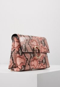 Borsa con motivo di pelle di serpente nei toni di rosa e marrone, dotata di una chiusura circolare dorata e un design strutturato con chiusura a patta.