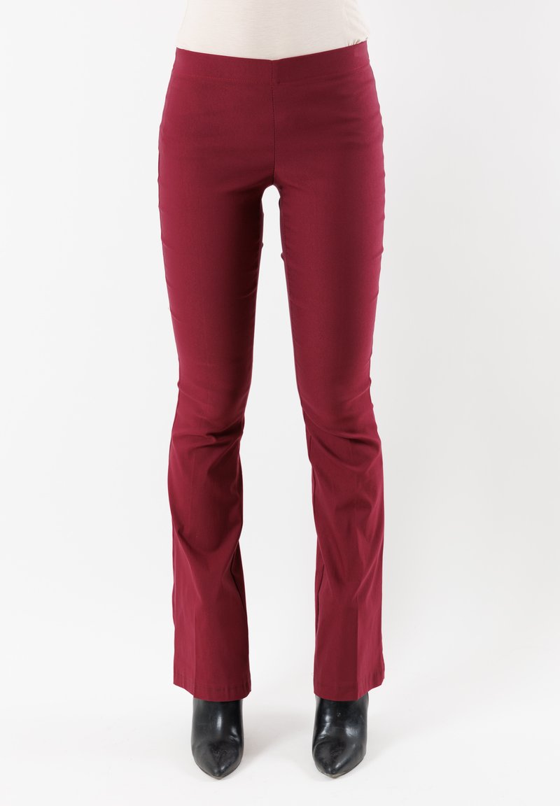 Pantaloni a zampa d'elefante bordeaux, morbido cotone misto, vita media, aderenti sulle cosce, svasati all'orlo, abbinati a décolleté nere a punta.