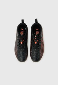 Μαύρα και πορτοκαλί αθλητικά παπούτσια Puma με κορδόνια, σε θέαση από πάνω σε λευκό φόντο.