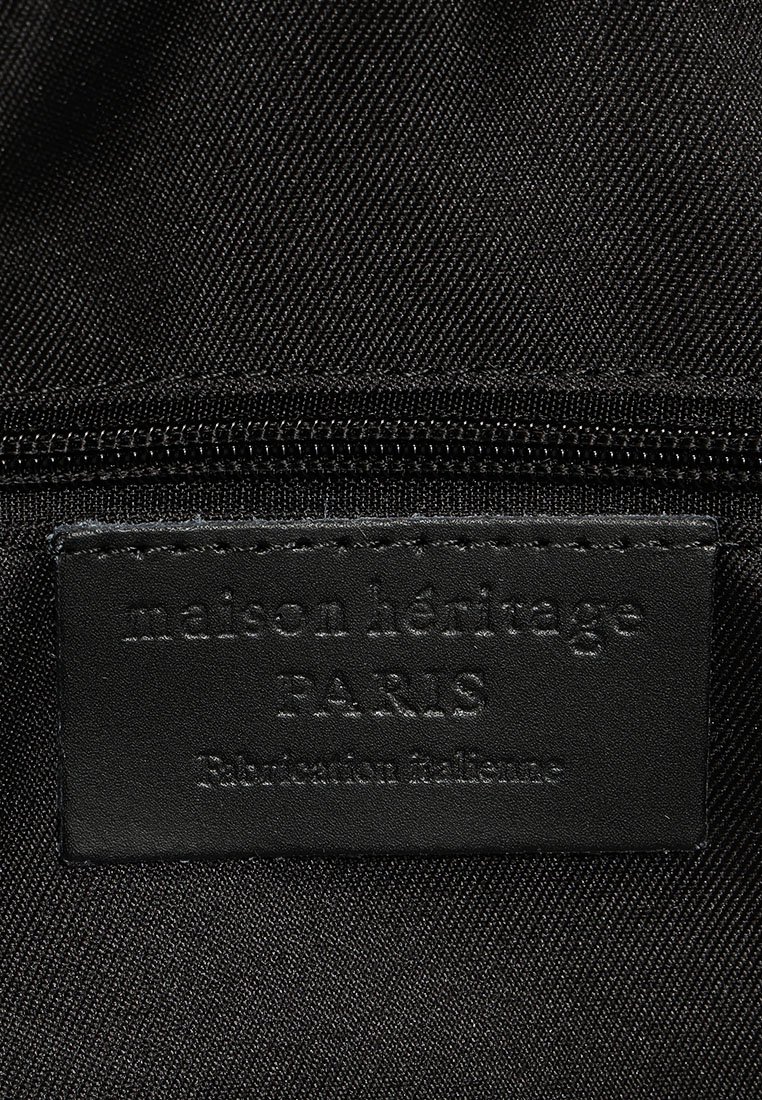 Etiqueta de tela negra cosida en un forro textil negro con texto en relieve "maison héritage PARIS Fabrication italienne."