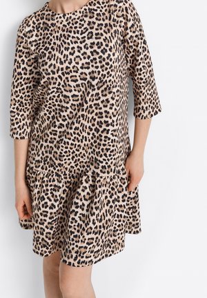 Sukienka w panterkę z rękawami do łokci, miękka tkanina, okrągły dekolt, falbaniasty dół na kilku poziomach, luźny fason w kolorach beżu i czerni.