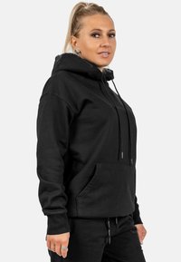 Felpa nera con cappuccio, coulisse, tasca frontale e maniche lunghe. Realizzata in tessuto morbido, presenta una vestibilità leggermente rilassata e dettagli cuciti.