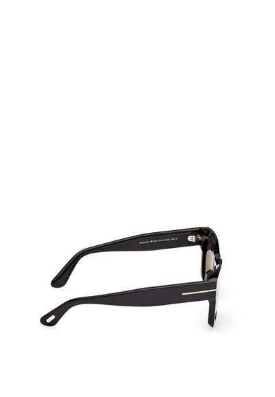 Czarne grube oprawki okularów z prostokątnymi soczewkami i subtelnymi złotymi akcentami na zausznikach, leżące na białej powierzchni.