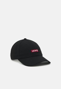 Casquette de baseball en coton noir avec une visière incurvée, ornée d'un patch rectangulaire rouge affichant le texte "LEVI'S" en blanc.