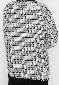 Schwarz-weißer, gemusterter, übergroßer Strickpullover mit strukturierter Oberfläche, mit einem gerippten Ausschnitt und Saum sowie eingefallenen Schulternaht.