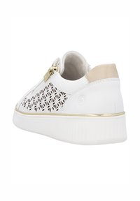 Weiße Sneaker mit ausgeschnittenem Blumenmuster, goldenen Akzenten, strukturiertem Sohlen und beigem Lederfersenbereich. Flache Schnürung.