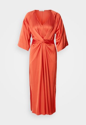 Robe satin orange avec un décolleté en V profond, des manches larges et un nœud à l'avant. La jupe comporte une fente latérale pour un détail supplémentaire.
