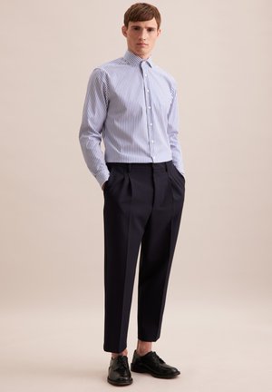 Striped button-up shirt in blue and white, paired with navy trousers. Features a tailored fit, long sleeves, and black lace-up shoes.