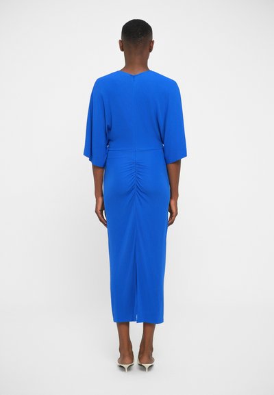 Modra obleka do kolen s oprijetim silhuetom, širokimi rokavi, naborki v predelu pasu in razporkom na sredini hrbta. Gladka tekstura.