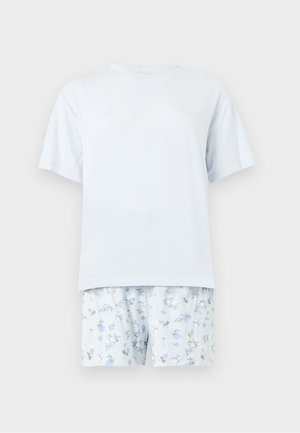 Lichtblauw T-shirt met korte mouwen gecombineerd met witte shorts met kleine blauwe en groene bloemenpatronen.
