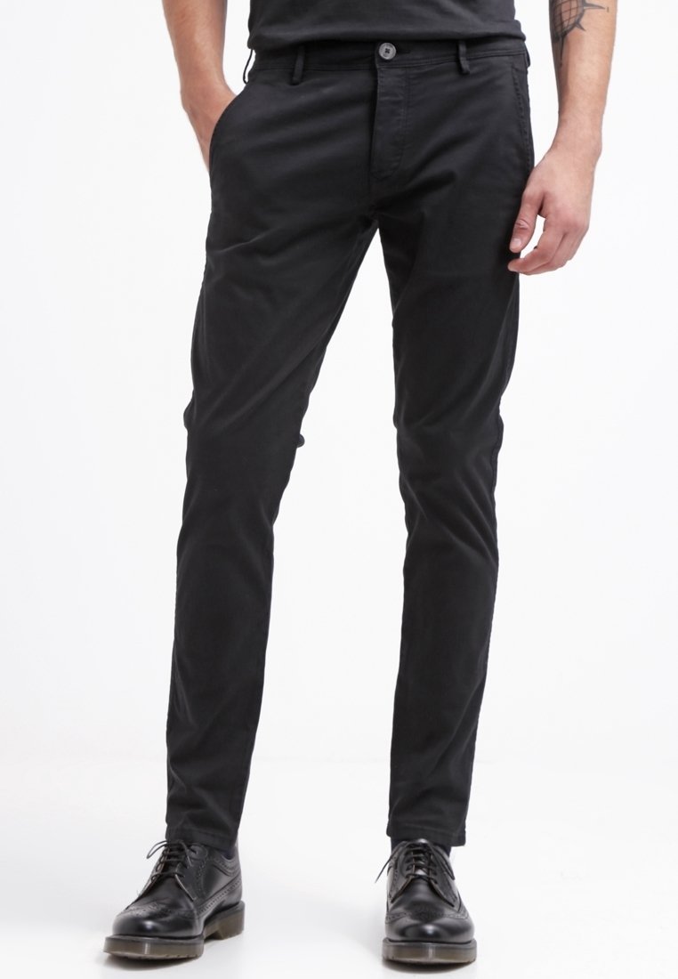 Svarta, slim-fit byxor i bomullsmaterial, med rak framdel, bältesloopar och en enkel knäppning. Bärs med svarta klädskor.