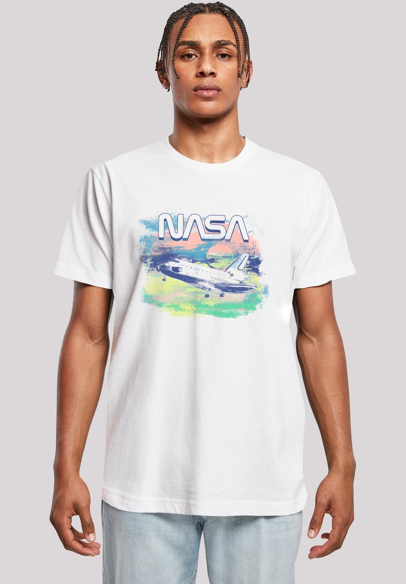 White cotton t-shirt featuring a multicolored graphic of a NASA space shuttle with bold text above. Short sleeves and a crew neckline.