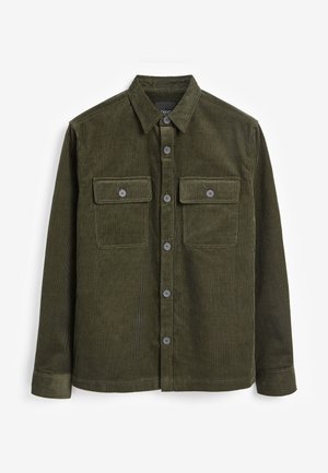 Chemise en velours côtelé vert foncé à manches longues avec patte de boutonnage à l'avant et deux poches poitrine à boutons, posée à plat sur un fond blanc.