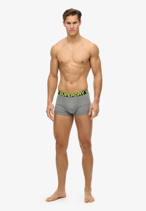 Boxers en coton gris avec une ceinture noire et jaune fluo portant l'inscription "SUPERDRY". Le tissu est lisse et ajusté.