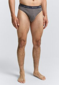 Herenboxershort, gemaakt van zachte stof, met een marineblauwe basis en een geometrisch patroon in wit en lichte kleuren, en een effen donkere tailleband.