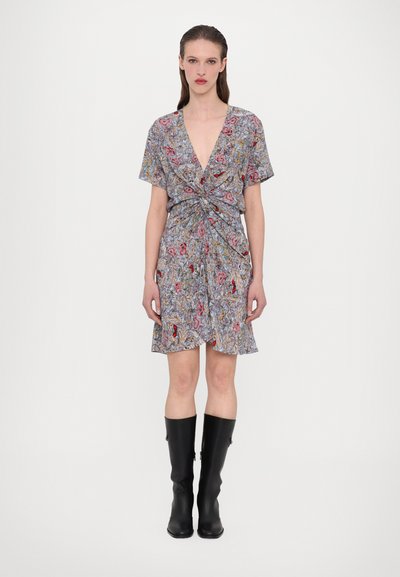 Robe imprimée gris avec des motifs floraux, dotée d'un décolleté en V profond, de manches courtes et d'un détail de nœud à la taille, associée à des bottes noires montantes.