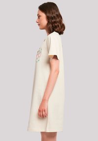 Beige Baumwollkleid mit kurzen Ärmeln und entspannter Passform, das ein farbenfrohes Stickdesign auf der Vorderseite und seitlichen Schlitzen für mehr Komfort aufweist.