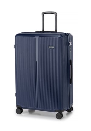 Navy hardshell suitcase with vertical ridges, telescopic handle, top and side carry grips, and four black wheels for mobility.