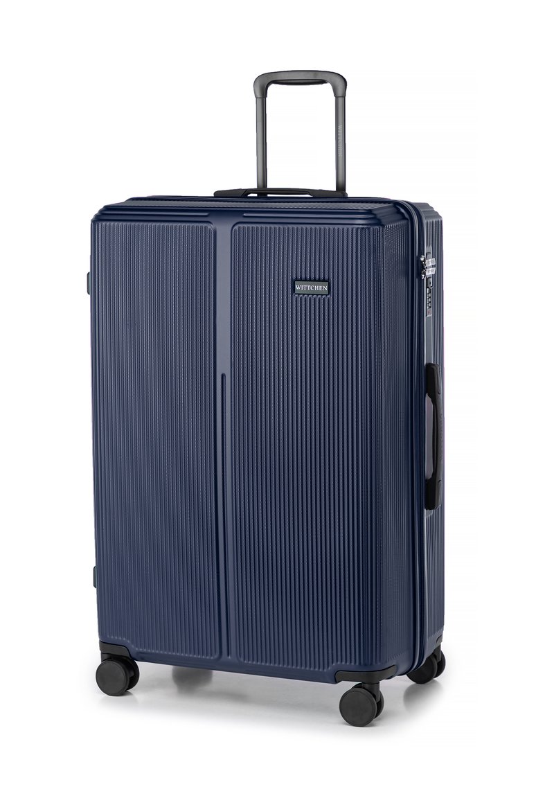 Valigia rigida blu navy con righe verticali, manico telescopico, maniglie di trasporto superiori e laterali, e quattro ruote nere per la mobilità.